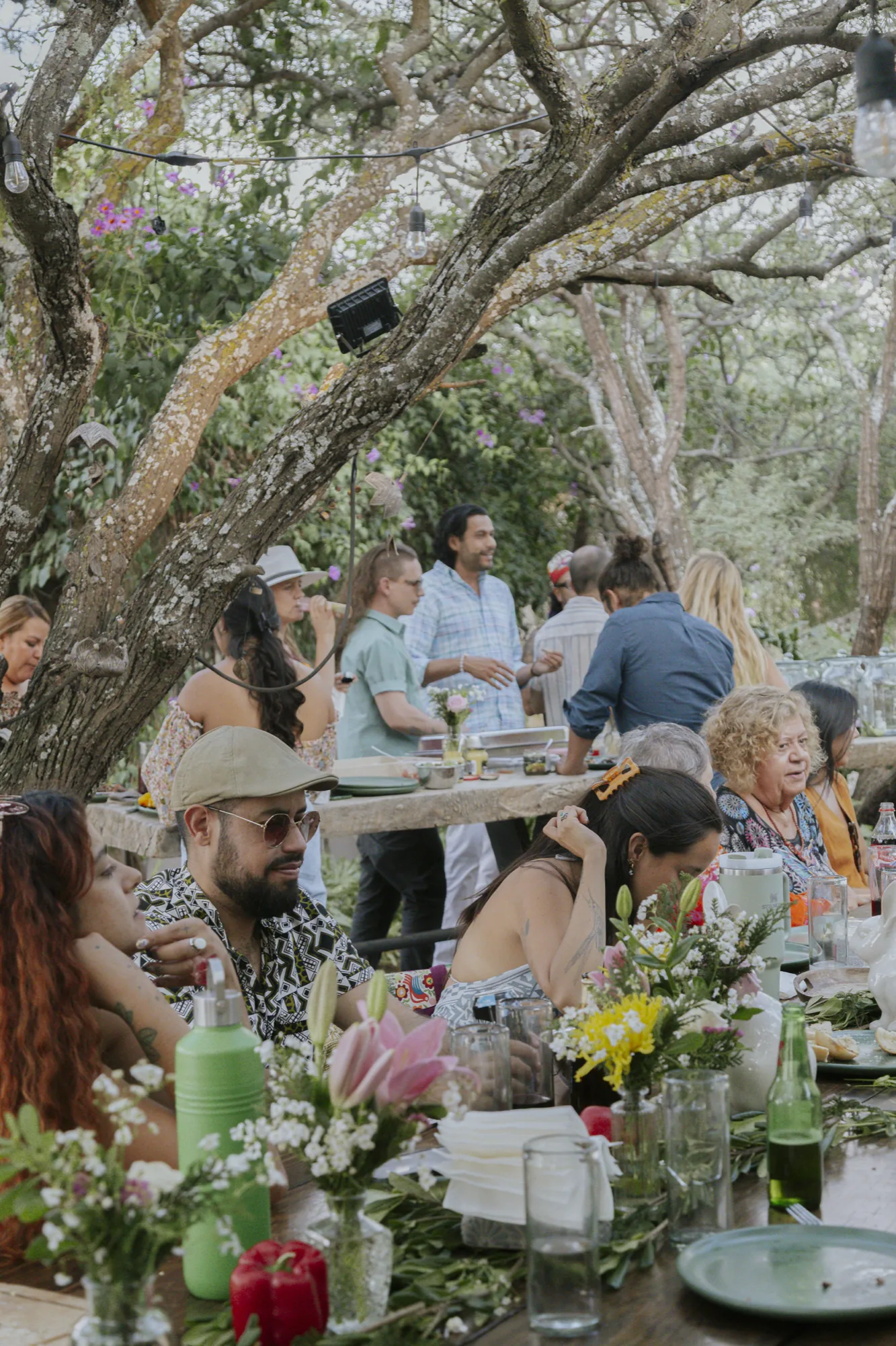 Grupo de personas conviviendo en los jardines de Casa X